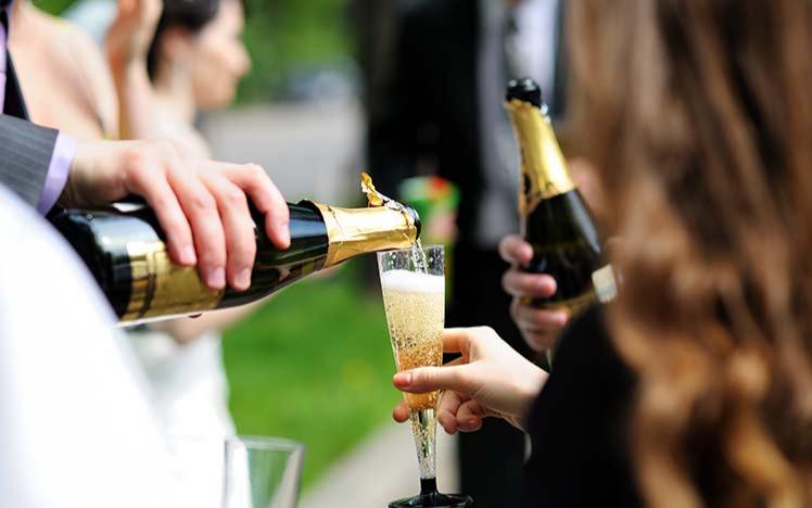 Person pouring champagne to another persons glass.