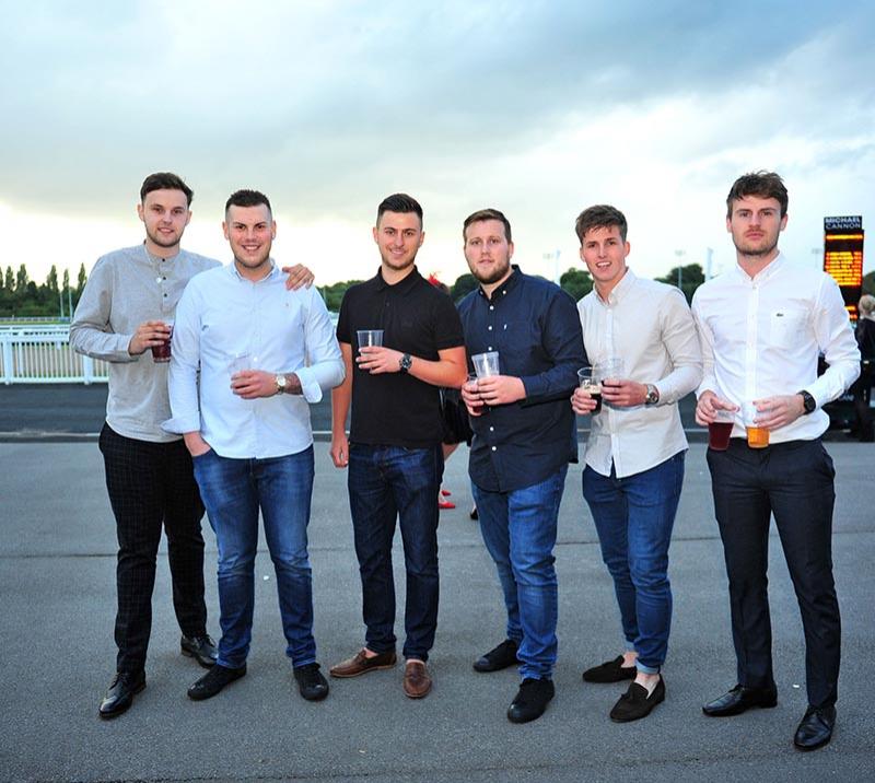 Group of gentlemen attending racing.