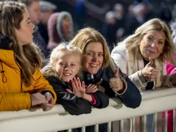 A family at the trackside at Wolverhampton Races give a thumbs up for the camera