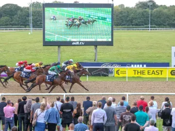 Crowds watch a very close race as the horses approach the finish line at Wolverhampton