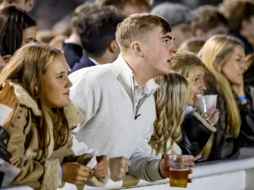 Race goer watches the track intensely at Wolverhampton Racecourse