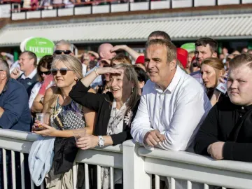The crowd at the trackside of Wolverhampton Races watch the race