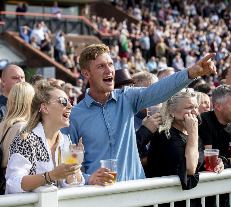 A young couple excitedly celebrate a win at the races at Wolverhampton