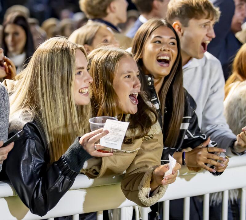 A young group of girls cheer for the horse racing at Wolverhampton