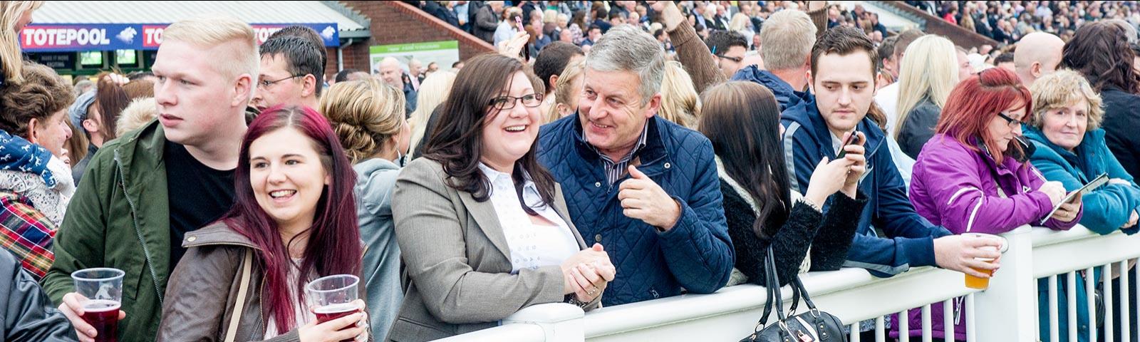 Group of people enjoying racing while standing in one of the enclosures.