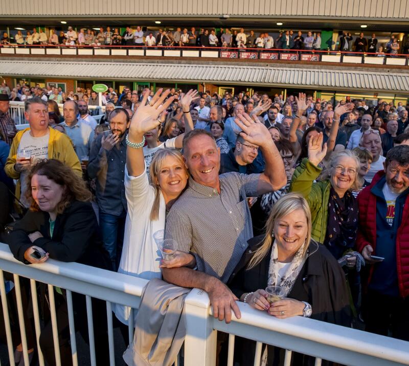 A couple wave to the camera amongst the crowd at Wolverhampton