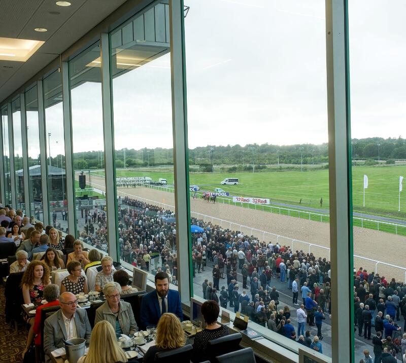 Wide view of crowds sitting inside the Horizon Restaurant, with more crowds visible outside the window.
