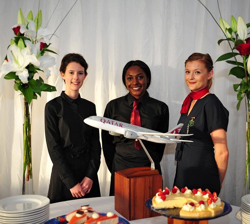 Three staff members standing behind a table.